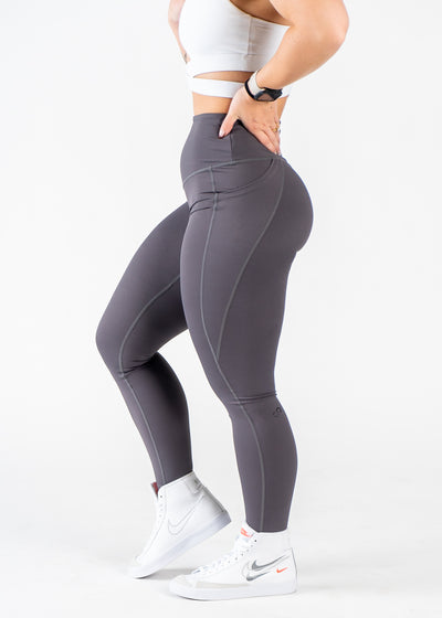 Chest Down Side View One Leg Up Wearing Empowered Leggings x FIT OPS | Grey