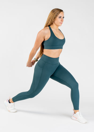 Full Body Side View Woman Performing Lunge and Stretching Hands Behind Back Wearing Empowered Double Brushed Leggings - Pine