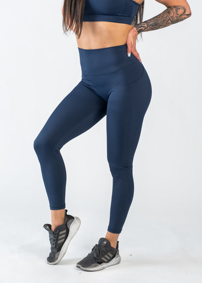 Chest Down 3/4 Front View One Leg Up Wearing Empowered Leggings With Pockets | Blue
