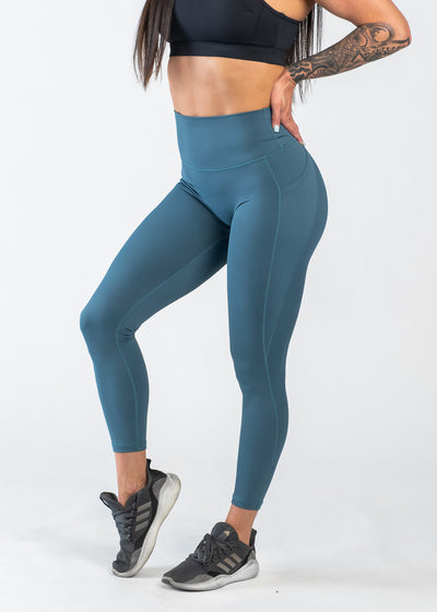 Chest Down 3/4 Front View One Leg Up Wearing Empowered Leggings With Pockets | Teal
